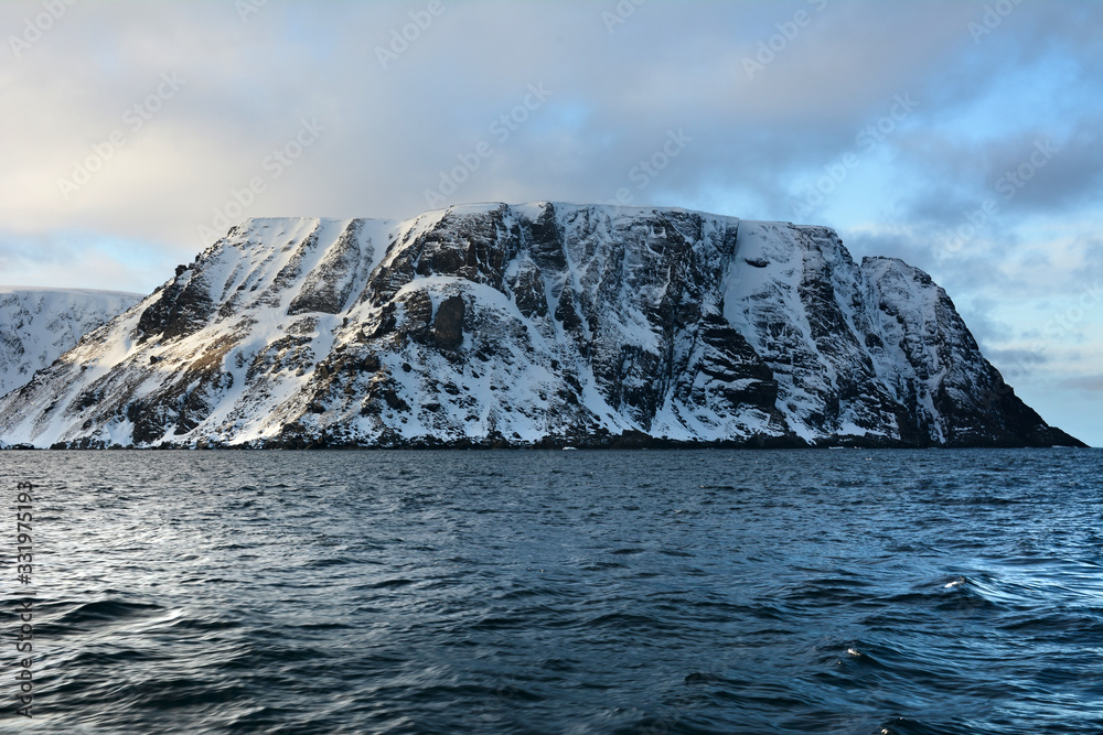 Nordkapp with snowy cliffs and blue water of Barents Sea