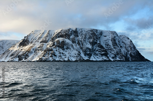 Nordkapp with snowy cliffs and blue water of Barents Sea photo