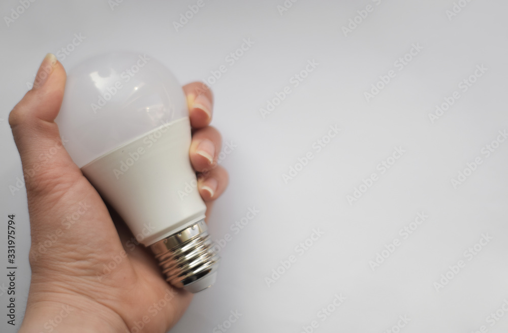 Hand holding a light bulb on white background Hand holding a light bulb on white background