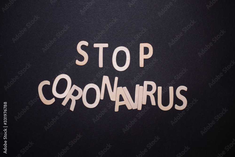 Obraz premium stop coronavirus written on black background with wooden letters
