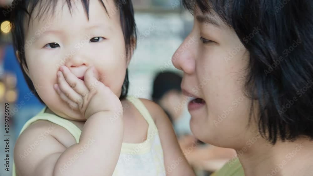 Close up mother and baby playing together with funny and happy emotion. Pretty asian woman take care her infant girl with attractive smile.Concept is family. Close up mother and baby playing together with funny and happy emotion. Pretty asian woman take care her infant girl with attractive smile.Concept is family.