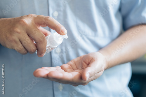 Close up man hands using wash hand sanitizer gel dispenser.