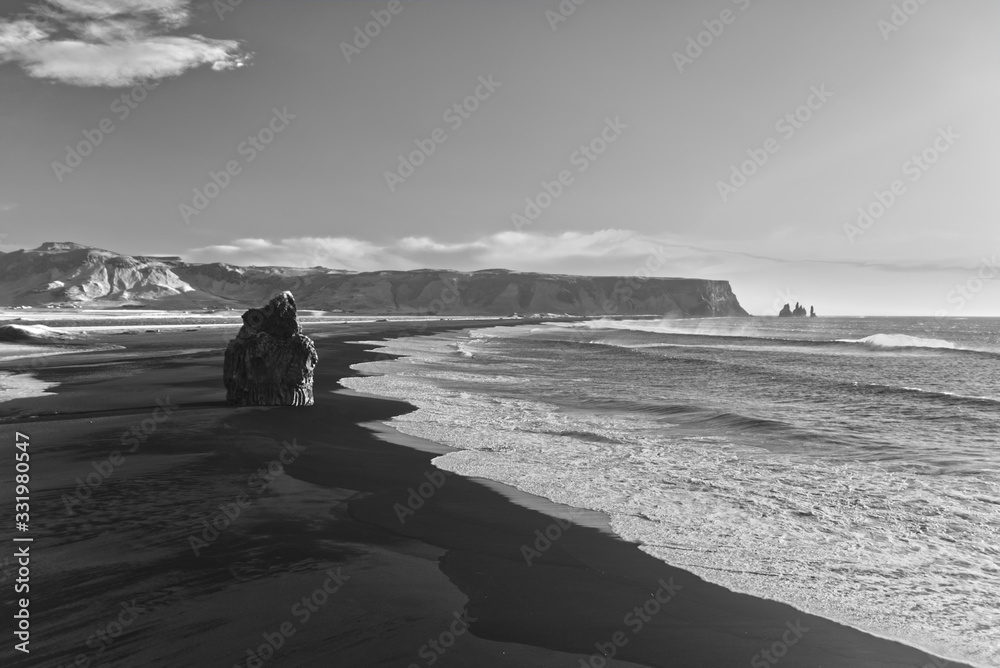 Iceland black beach with waves and rock in black and white