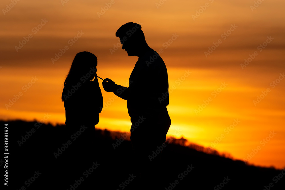 Lovers couple in sunset time in nature shilouette