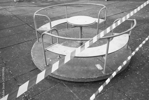No entry barrier tape in front of an abandoned carousel, due to the quarantine restrictions activated to combat the Coronavirus pandemic.