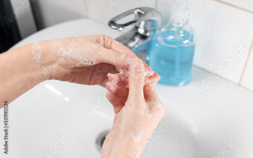 Hand washing in accordance with the rules of the Ministry of Health. The threat of viral diseases, the epidemic of coronavirus, Covid-19, flu. Young woman washes hands with liquid soap. Series 4
