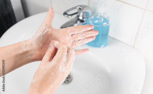 Hand washing in accordance with the rules of the Ministry of Health. The threat of viral diseases, the epidemic of coronavirus, Covid-19, flu. Young woman washes hands with liquid soap. Series 5