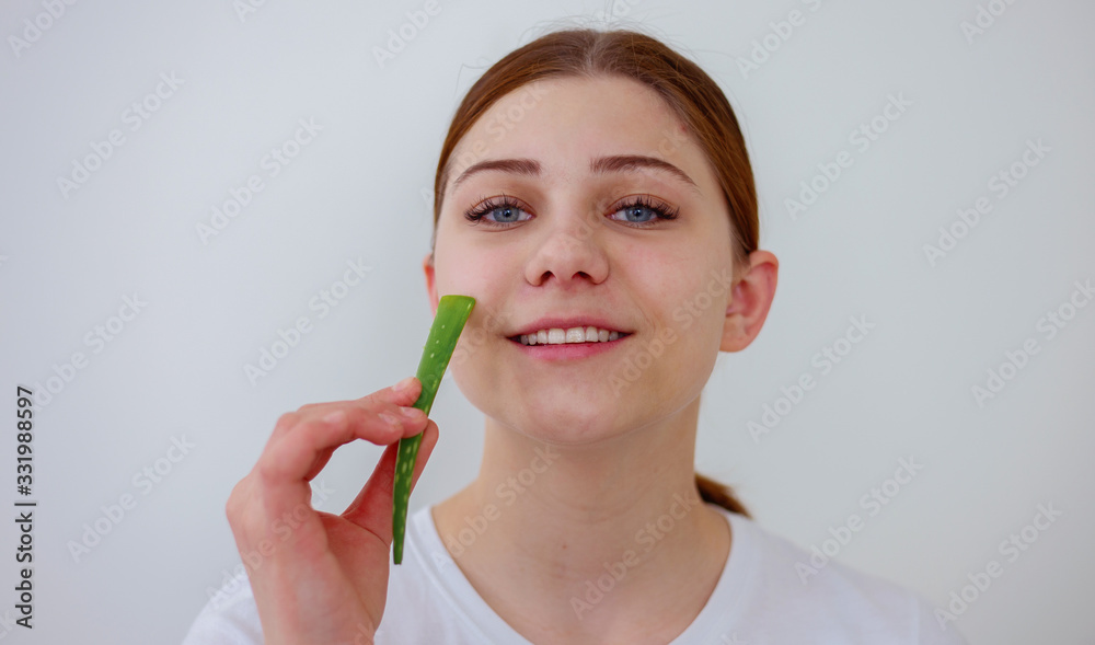 Woman with clear skin holding green aloe vera leaf Woman with clear skin holding green aloe vera leaf