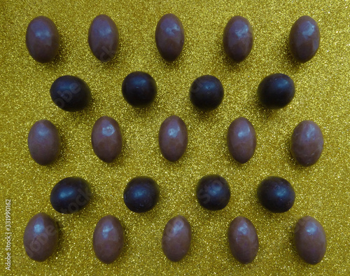 Several chocolate eggs on a gold background in a separate pattern