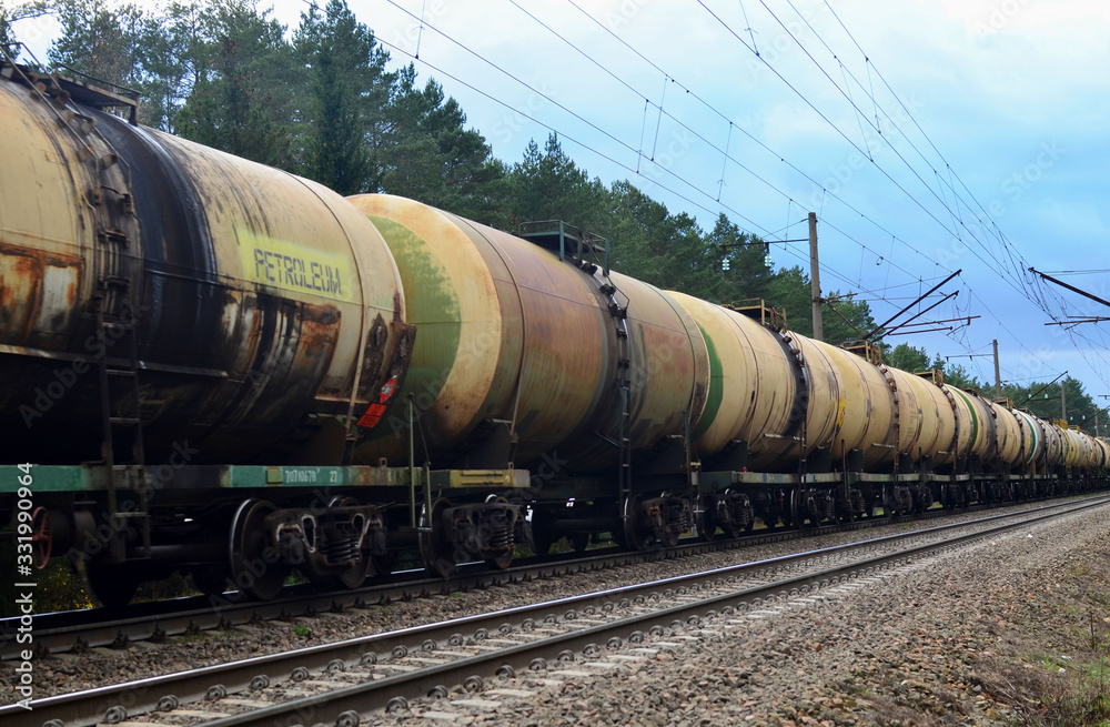 Freight train with petroleum tank cars on railroad. Rail cars carry oil and ethanol. Railway logistics explosive cargo. Transportation of methanol, crude and gas.Petrochemical tank cars Freight train with petroleum tank cars on railroad. Rail cars carry oil and ethanol. Railway logistics explosive cargo. Transportation of methanol, crude and gas.Petrochemical tank cars
