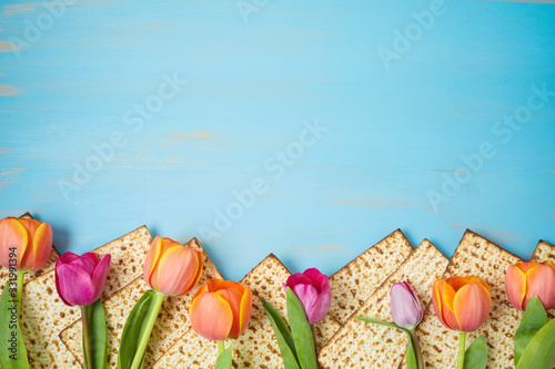 Foto Jewish holiday Passover celebration concept with matzah and tulip flowers on wooden table