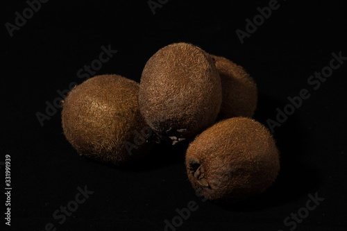 Bunch of kiwi on a black background. Kiwi is a tropical healty fruit