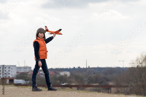 Boy playing in nature with a model of a glider (airplane).