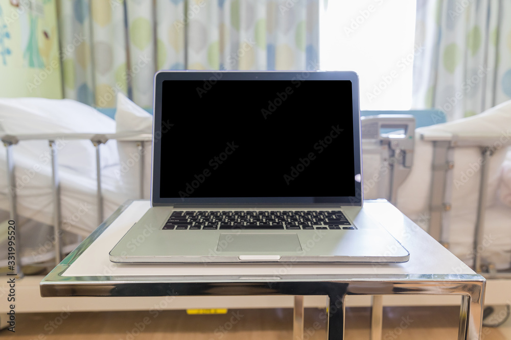 Blank computer laptop PC on table in hospital ward. Blank computer laptop PC on table in hospital ward.