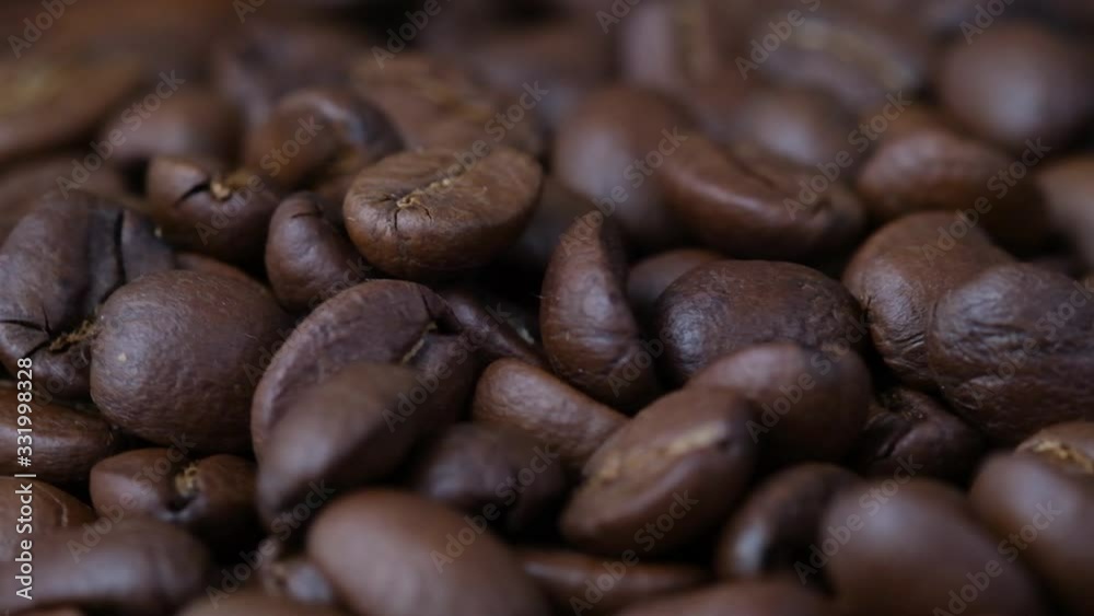 Coffee beans falling on dark coffee grains Coffee beans falling on dark coffee grains