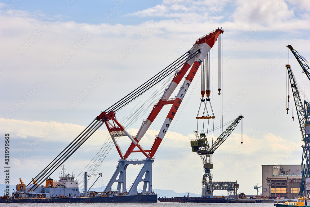 Huge crane is lifting smaller crane in the port