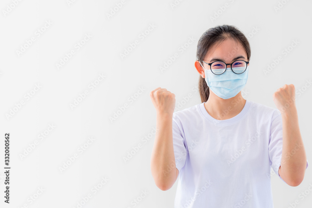 Portrait Asian young woman wears glasses and mask to protect against Coronavirus, girl show a fist encourage to fight contagious disease concept stop virus Covid 19 outbreak to win on white background Portrait Asian young woman wears glasses and mask to protect against Coronavirus, girl show a fist encourage to fight contagious disease concept stop virus Covid 19 outbreak to win on white background