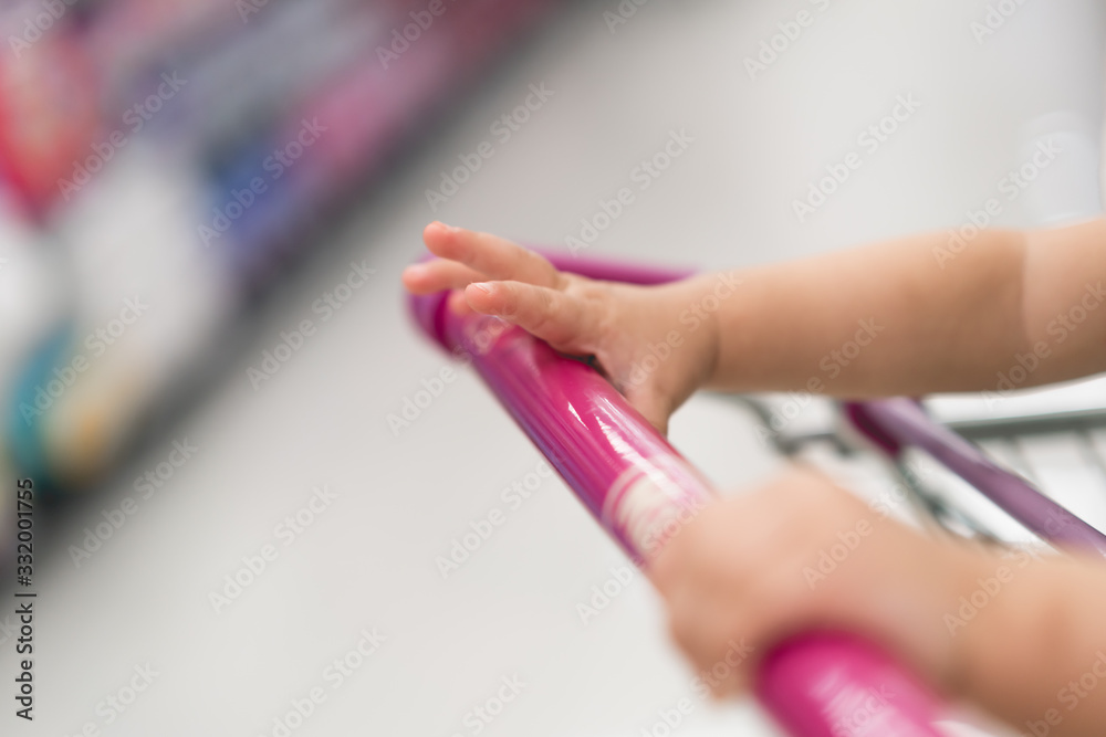 Baby hand with shopping cart in suppermarket Baby hand with shopping cart in suppermarket