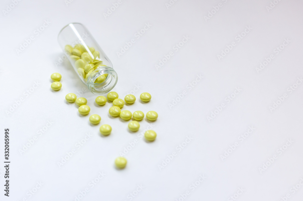 Yellow pills with bottle on white Yellow pills with bottle on white
