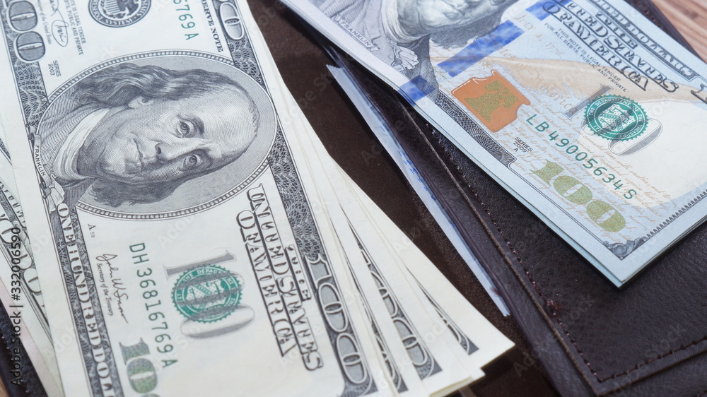 American dollars stacked on a dark background, in a wallet, in a cash drawer American dollars stacked on a dark background, in a wallet, in a cash drawer