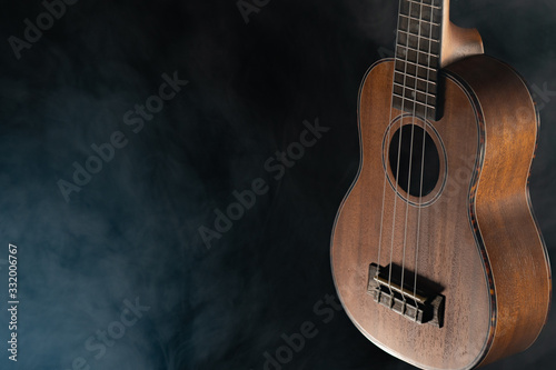 Hawaii ukulele guitar isolated against black background with smoke photo