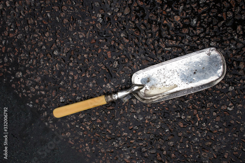 Cake spatula lies on gray wet asphalt © elenarostunova