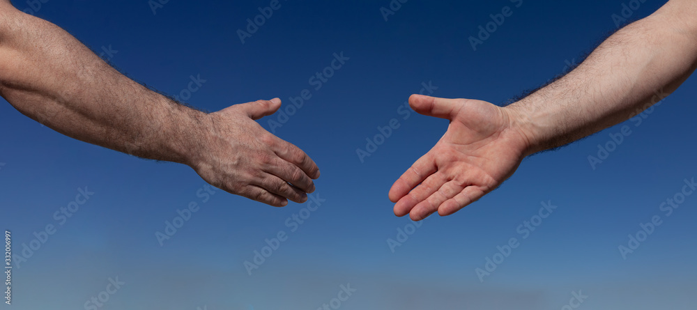 Two male hands on a blue background almost shaking hands, keeping a safe distance