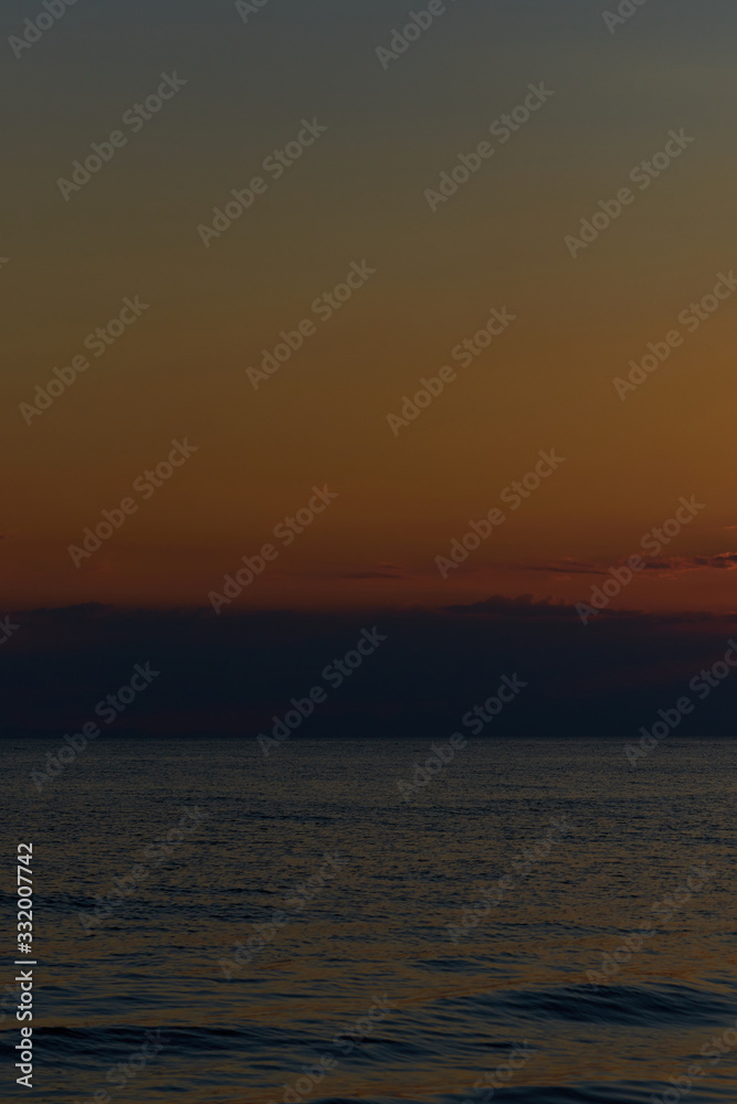 Sunset at the tropical beach, sun behind clouds reflects on water. Sunset at the tropical beach, sun behind clouds reflects on water.