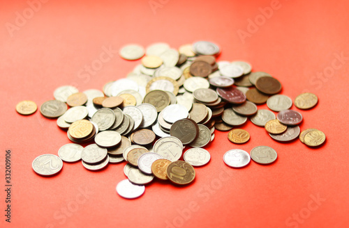 A bunch of different metal coins on a red background. A lot of Russian rubles. Selective focus. Collecting