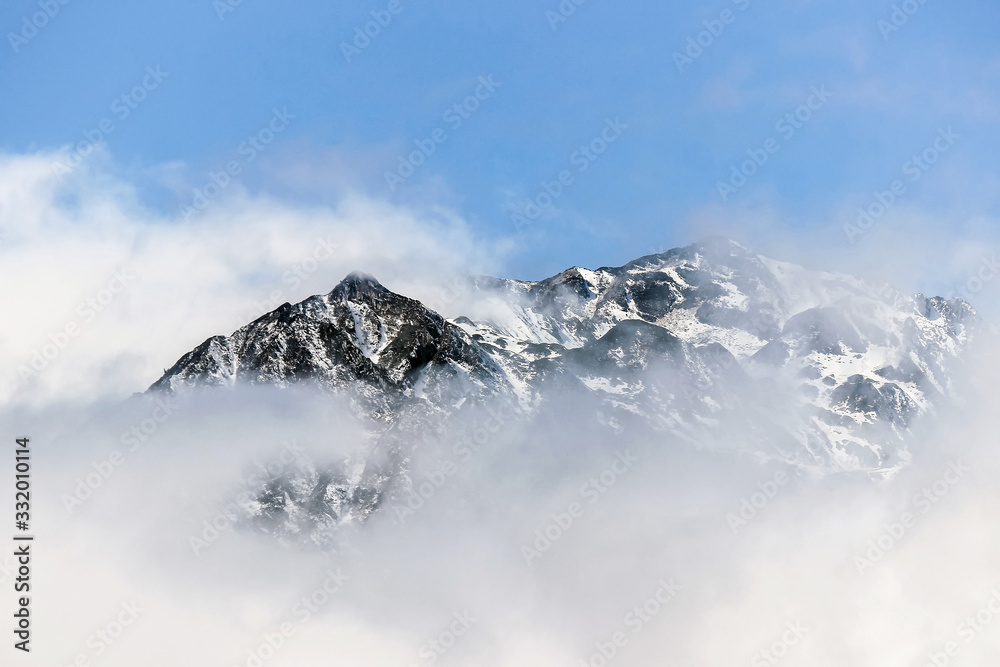 winter landscape of snow mountain peak in fog 