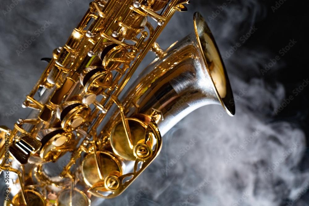 Golden shiny alto saxophone on black background with smoke. copy space - obrazy, fototapety, plakaty 