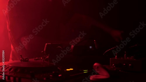 DJ plays a set at the party. Musical equipment. Light from party lights.