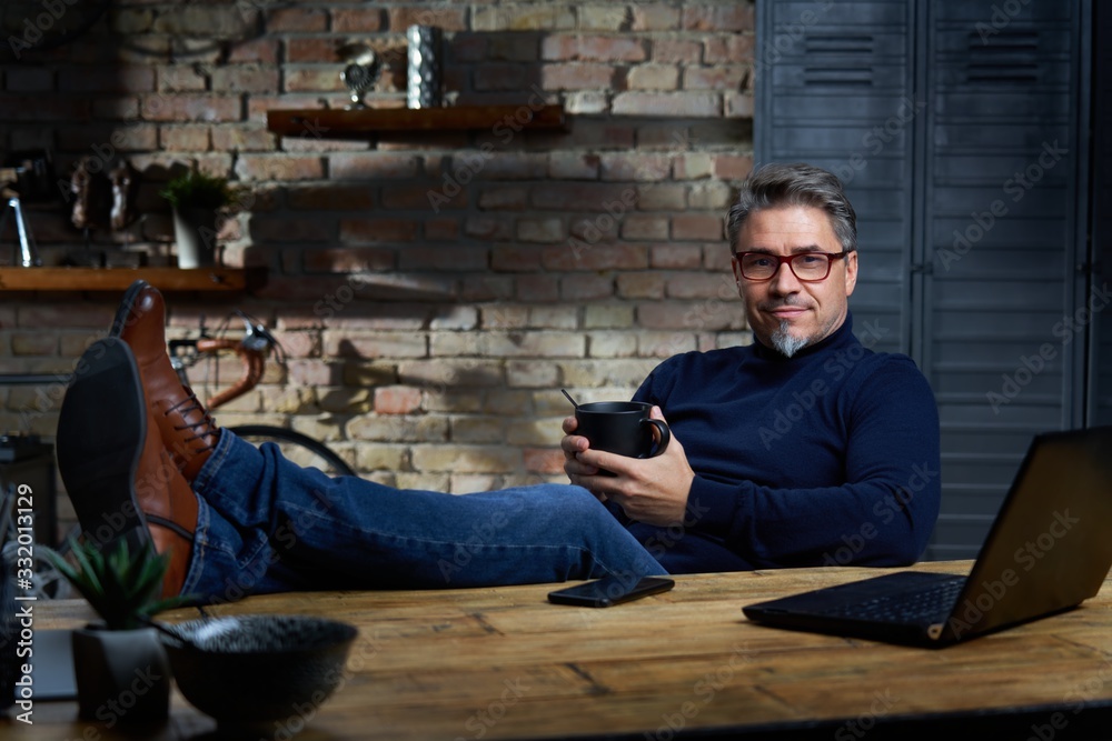 Man sitting at desk at home using phone Man sitting at desk at home using phone