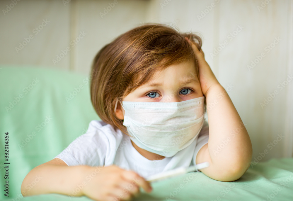 a little girl, wearing a medical mask, plays at home, in home quarantine, during the coronavirus pandemic,COVID-2019 a little girl, wearing a medical mask, plays at home, in home quarantine, during the coronavirus pandemic,COVID-2019