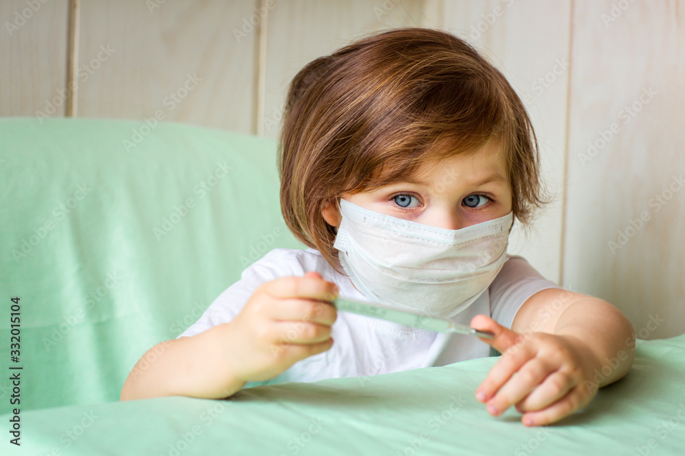 a little girl, wearing a medical mask, plays at home, in home quarantine, during the coronavirus pandemic,COVID-2019