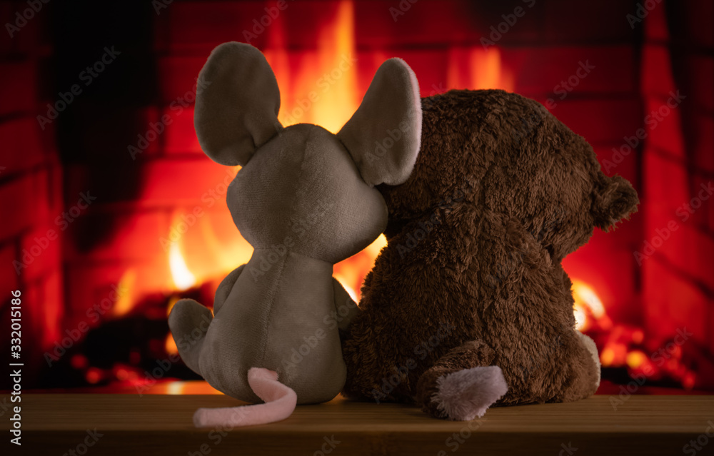 two children's toys bask near the Christmas fireplace in anticipation of the holiday, miracle and magic. New Year's Eve by the burning fireplace. love, warmth, family, hugs, trust,