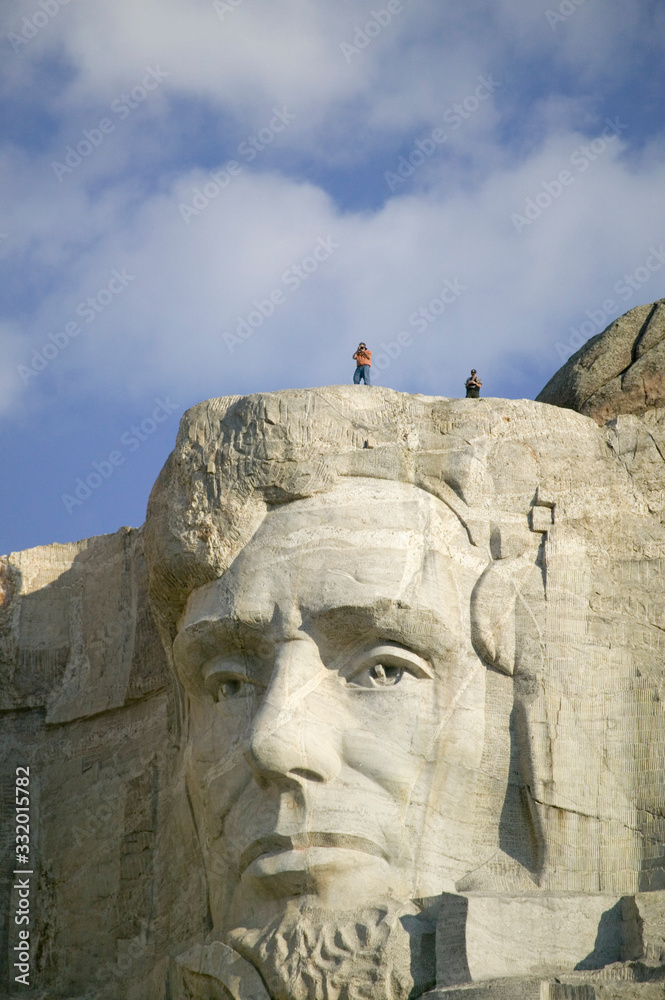 A park ranger and photographer standing above Abraham Lincoln at Mount Rushmore National Memorial, South Dakota