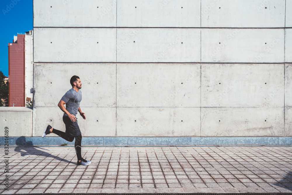 Strong man jogging in street of modern city Strong man jogging in street of modern city