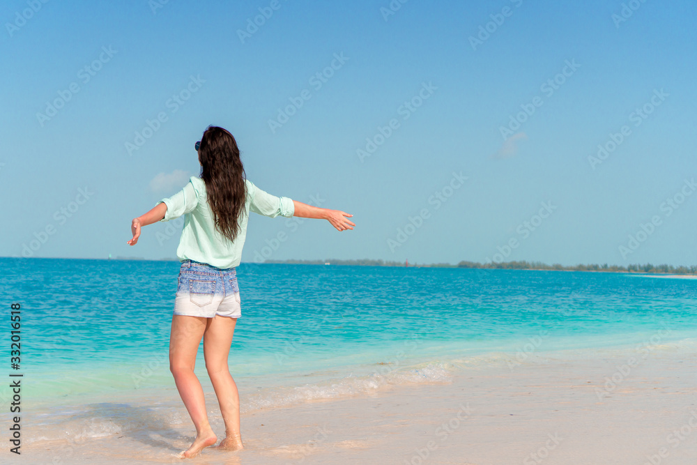 Woman laying on the beach enjoying summer holidays looking at the sea