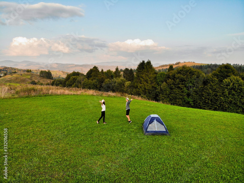 Aerial view of love couple of hikers spend time together away from city bustle by sunrise in camping day