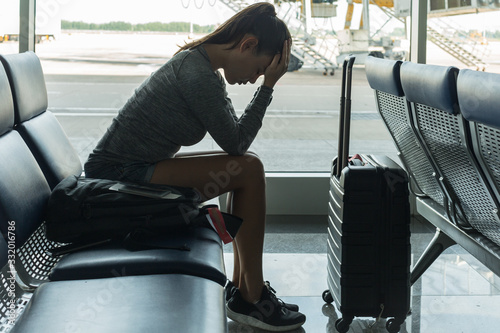 A passenger waiting at the airport terminal stressed out at tired. photo