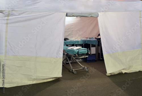 Empty hospital field tent for the first AID, a mobile medical unit of red cross for patient with Corona Virus. Interior camp room with folding camp bed for people infected with an epidemic. Covid-19. 
