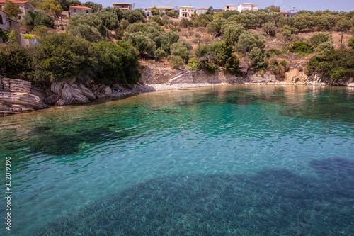 Fototapeta Naklejka Na Ścianę i Meble -  Kastos island summer picturesque nature with turquoise crystal clear water, rocky beach, green trees, houses - Ionian sea, Greece.