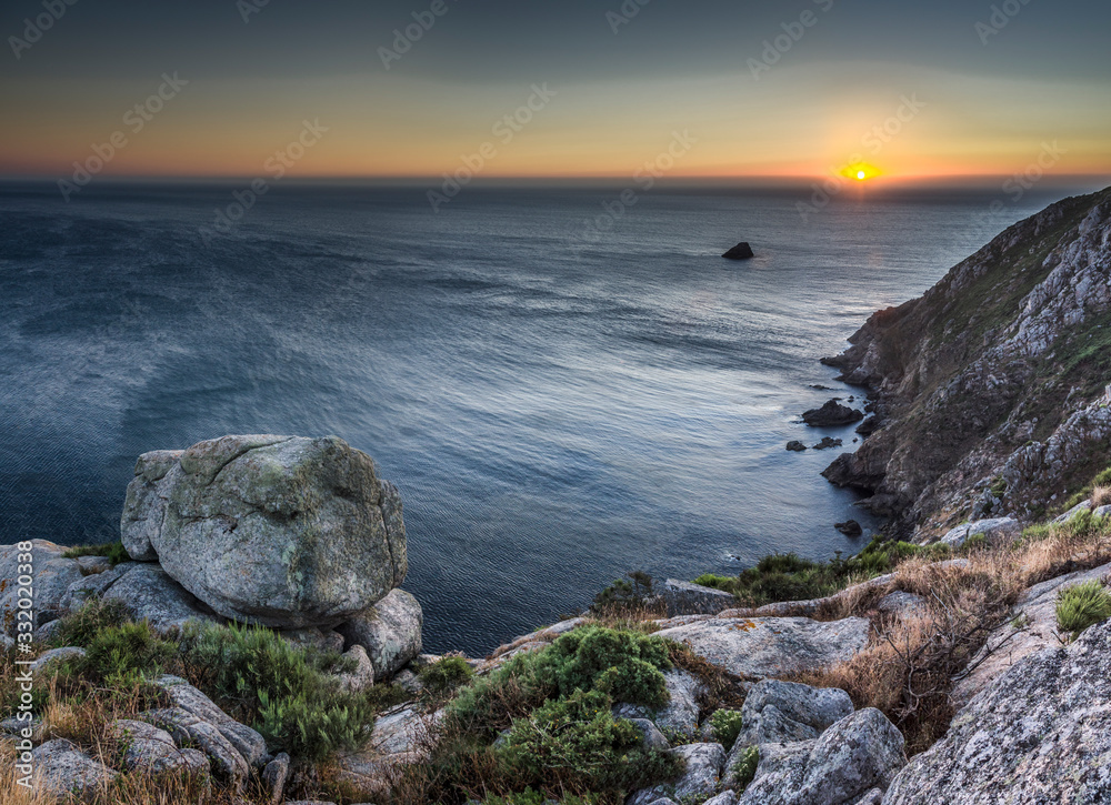 Puesta de sol en el mar desde la costa de Finisterre (Galicia, España).
