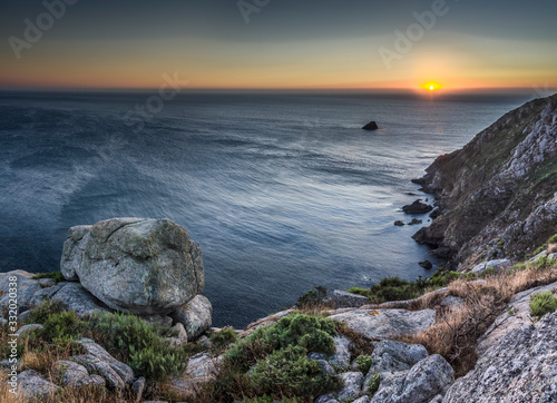 Puesta de sol en el mar desde la costa de Finisterre (Galicia, España).