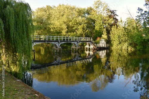 An old white bridge over the river and green trees around