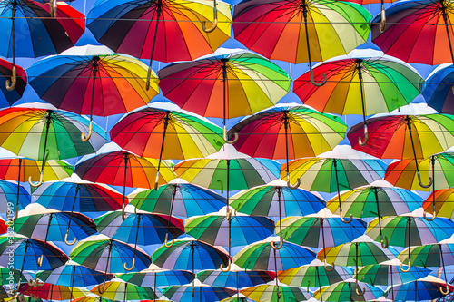Colorful umbrellas Blue, green, red, rainbow umbrellas background Street with umbrellasin the sky Street decoration.