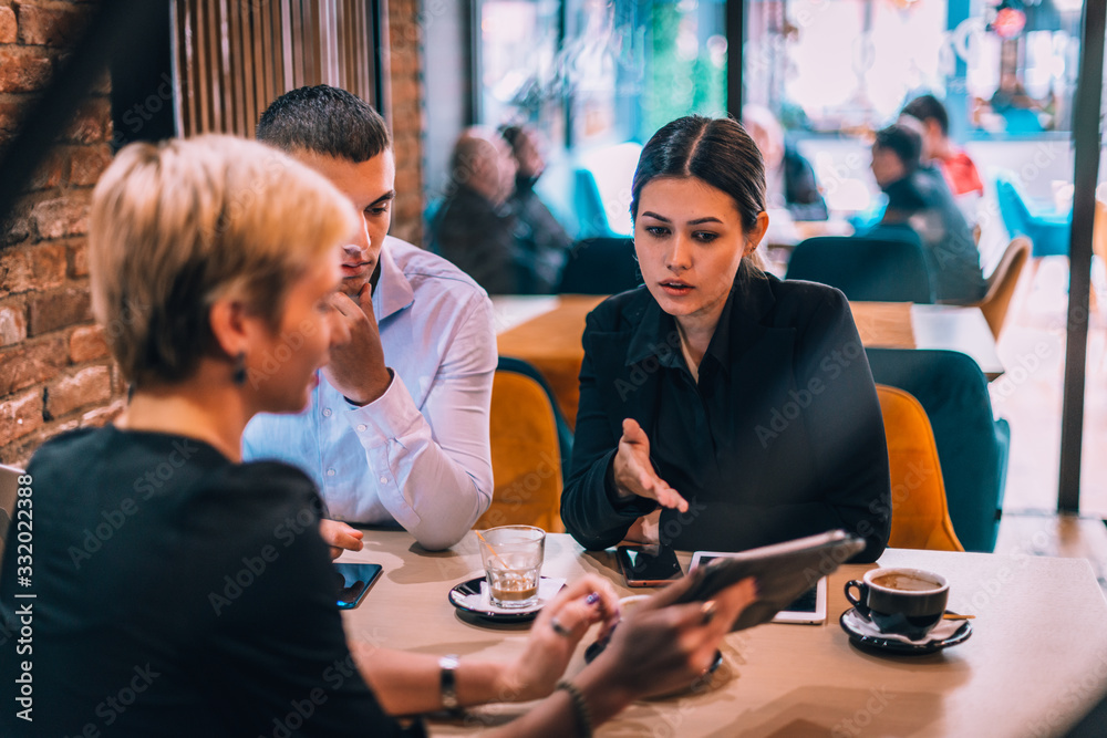 Fototapeta premium Lovely couple having meeting in the cafe with their business consultant