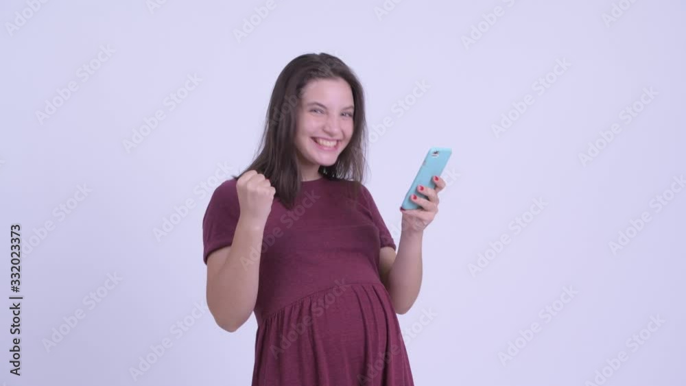 Happy young beautiful pregnant woman using phone and getting good news Happy young beautiful pregnant woman using phone and getting good news