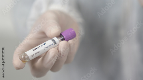Başlık: A doctor takes blood with syringe for coronavirus Covid-19 test in lab.
